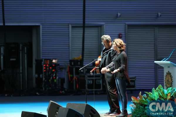 Amy Grant joins Vince Gill onstage following his performance of "Go Rest High On That Mountain" to lead a prayer in support of the Las Vegas shooting victims during a candlelight vigil in Nashville Monday at Ascend Amphitheater. Photo Credit: Hunter Berry/CMA