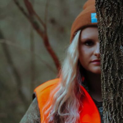 Dallas Remington in hunting gear behind a tree